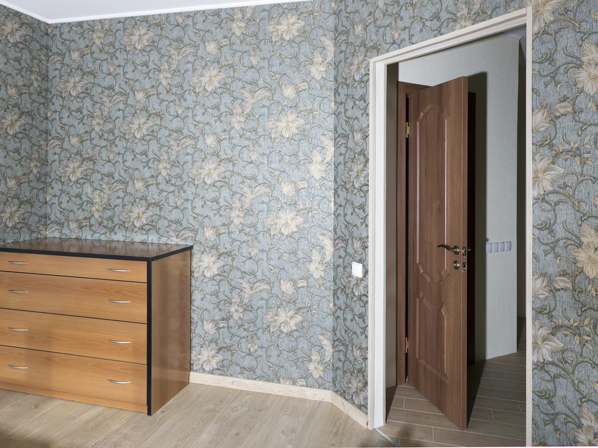 Bedroom wallpapering in Windsor showing blue floral pattern installation by Windsor Decorators