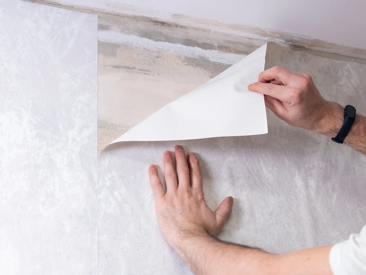 Hands applying wallpaper in professional hanging technique by Windsor Decorators